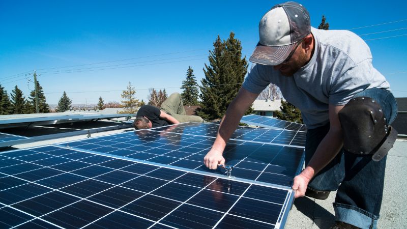 Güneş paneli Google Ads başarı hikayesi Güneş paneli kurulumu için Google Ads reklam kampanyası - Çatıda panel montajı yapan teknisyenler