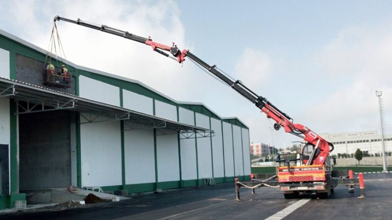 Vinç kiralama Google Ads başarı hikayesi Vinç kiralama firması için Google Ads reklam kampanyası - İnşaat sahasında çalışan kırmızı vinç